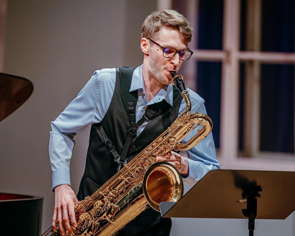 A saxophonist in the midst of an intense performance, surrounded by the soft glow of cello lights casting a gentle ambianc...